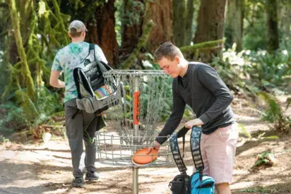 two students playing disc golf