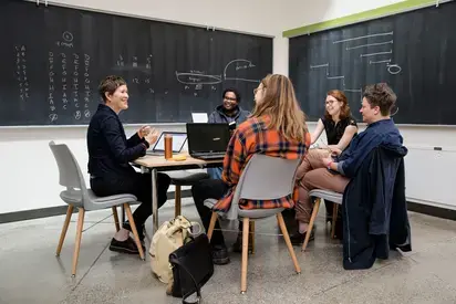 four people around a table smiling and having a discussion