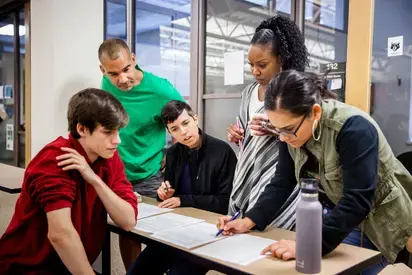 A diverse group of people work together on a project