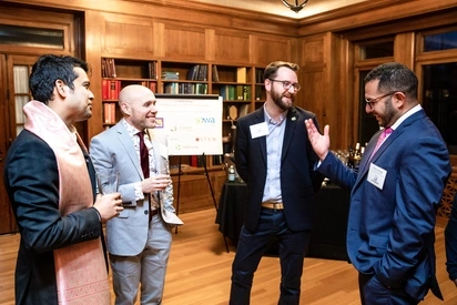 Four people in formal wear at a fundraising event