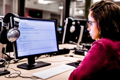 Student sits at computer desktop, reading about programming languages