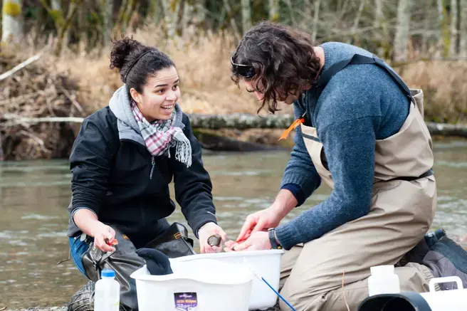 two students on a field trip by the river 