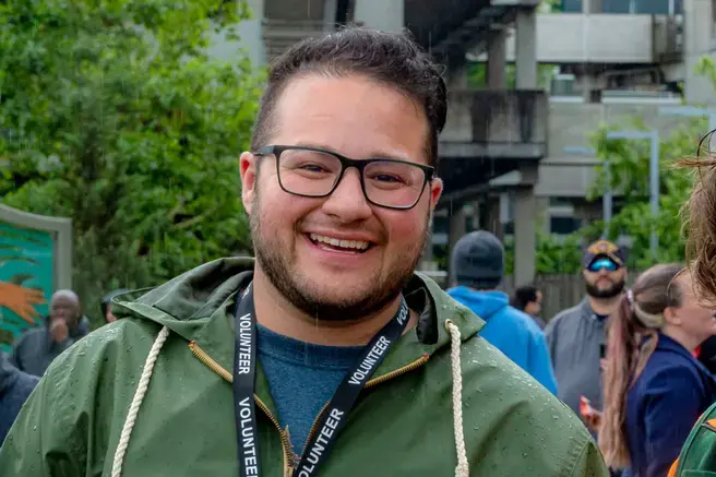 Photo of Sam Fennell smiling and wearing a green jacket outdoors