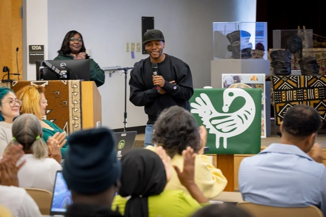 Two students presenting to a small group of others