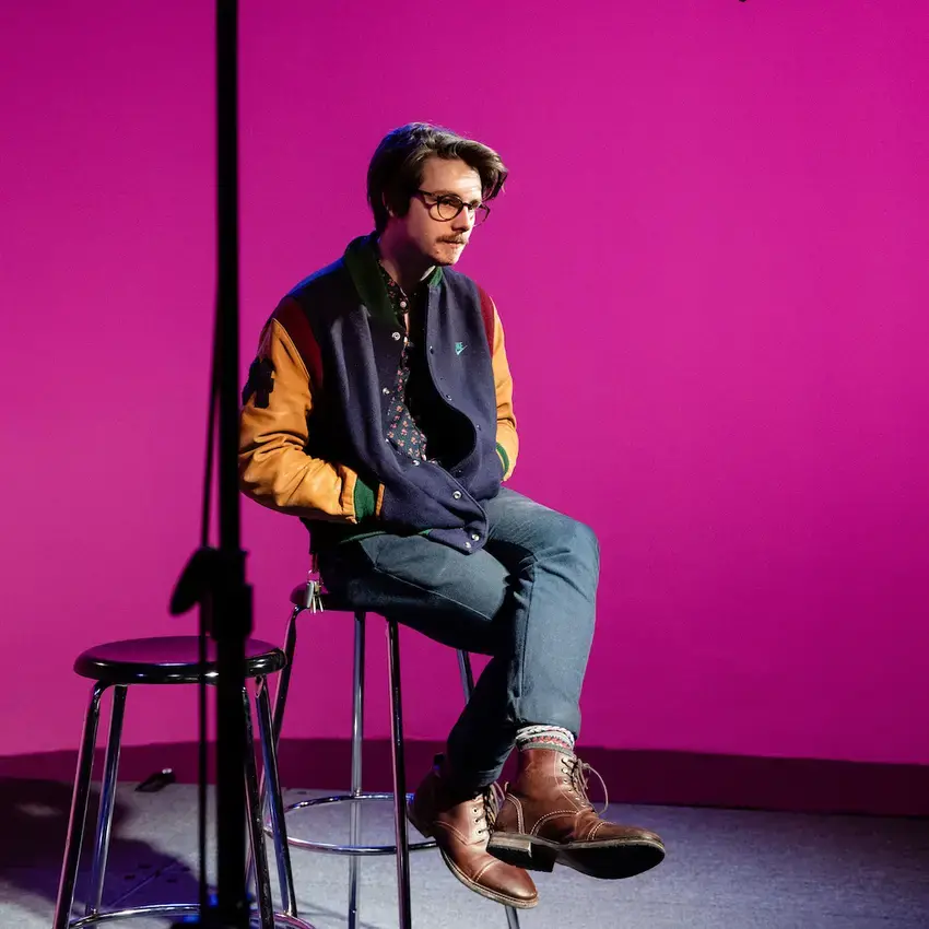 student in television studio with magenta color background