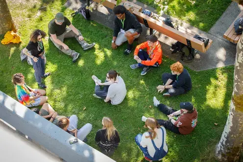 Students sitting in a circle outside